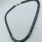 Halskette aus Hämatitwürfeln mit goldfarbenen Elementen