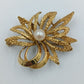 Elegante goldfarbene Brosche mit Perle