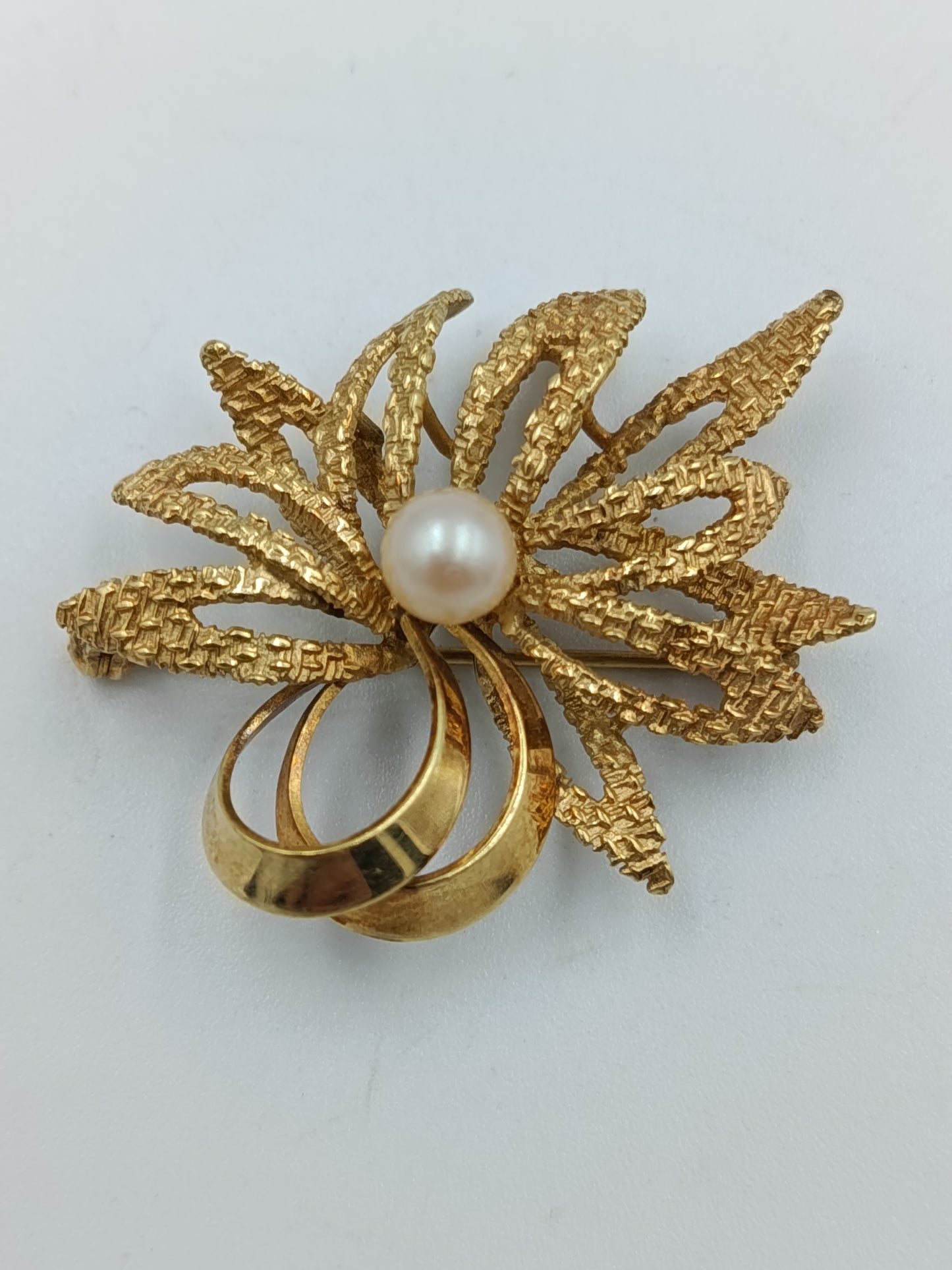 Elegante goldfarbene Brosche mit Perle