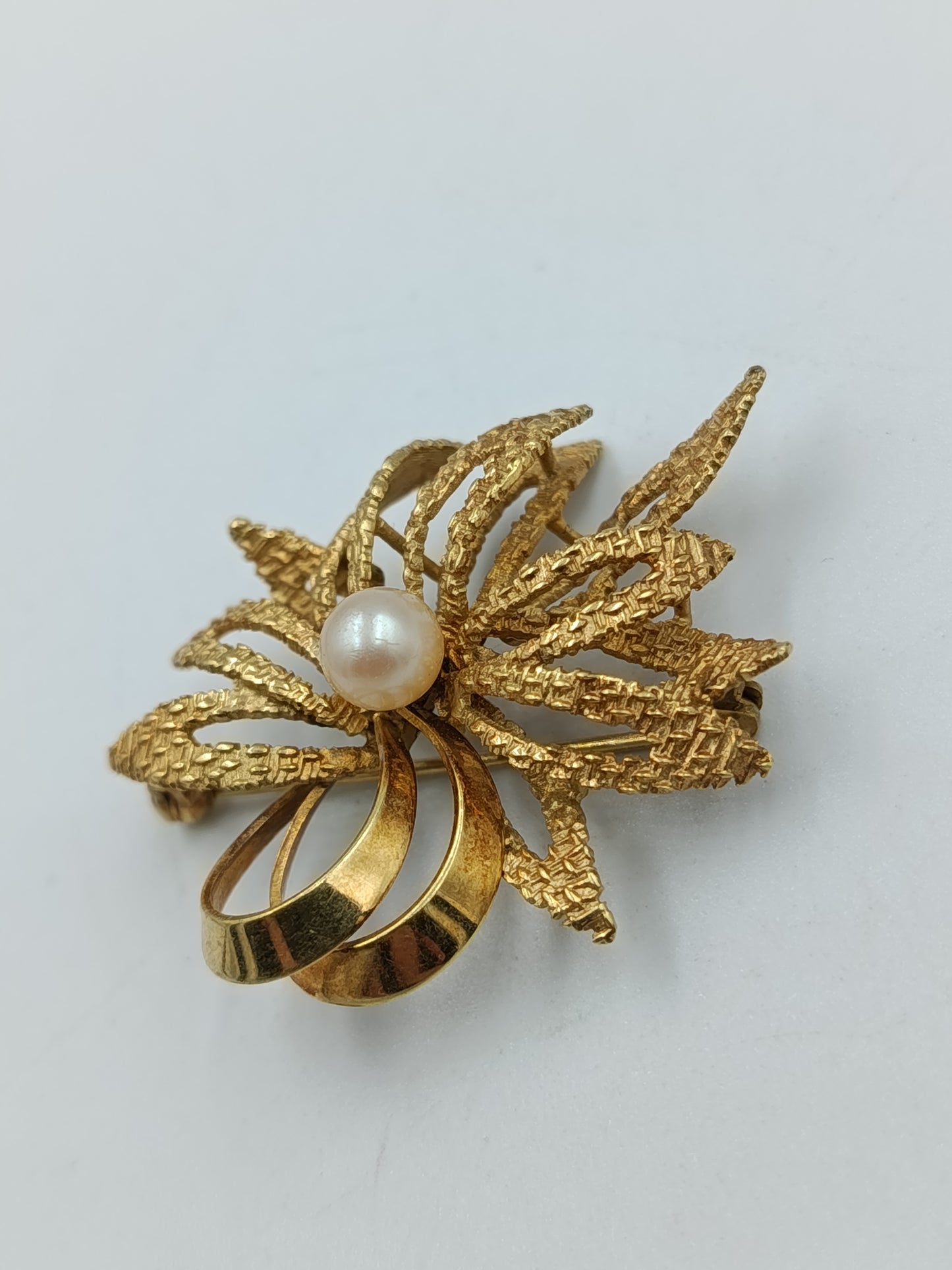 Elegante goldfarbene Brosche mit Perle