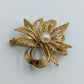 Elegante goldfarbene Brosche mit Perle