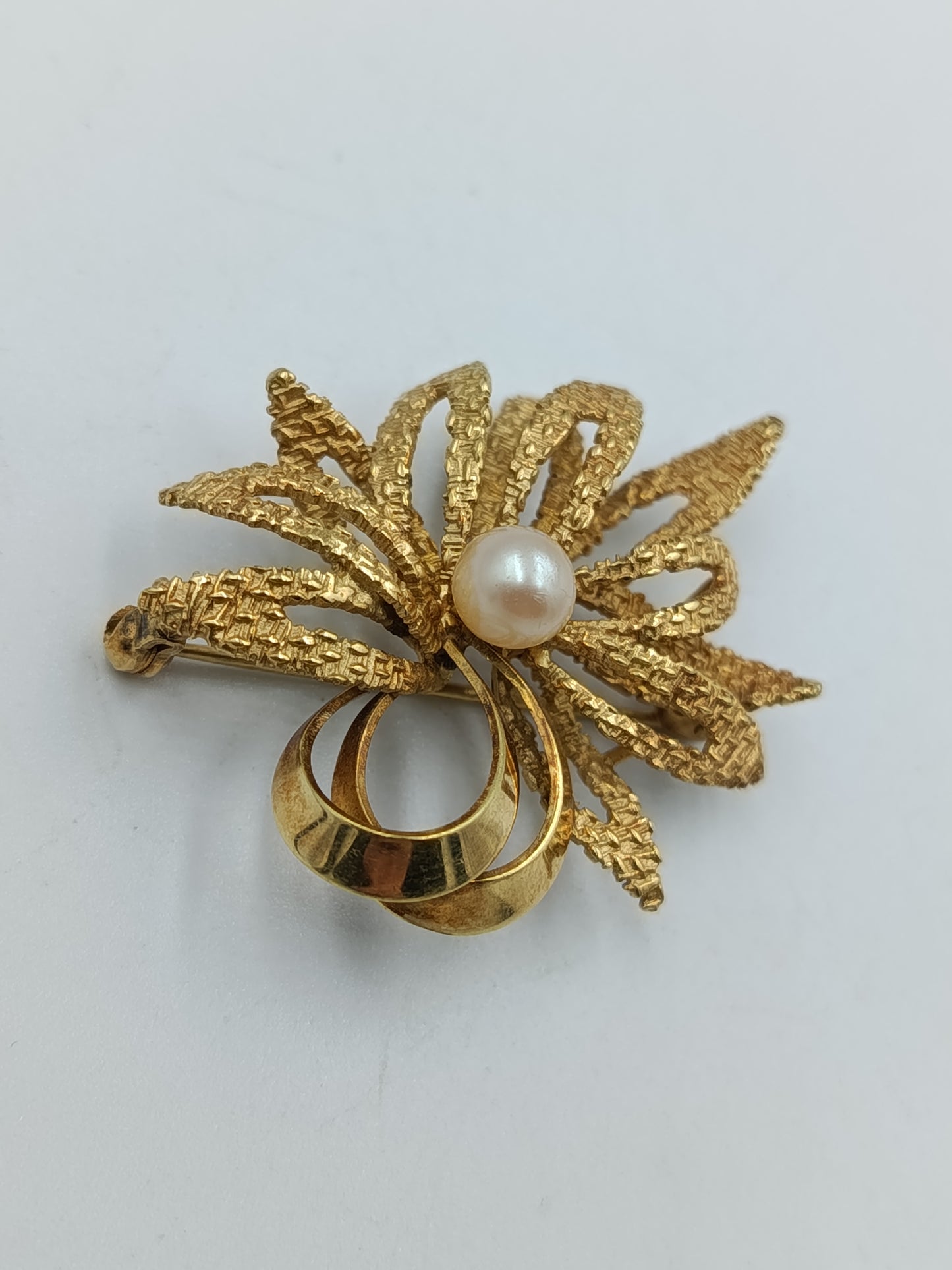 Elegante goldfarbene Brosche mit Perle