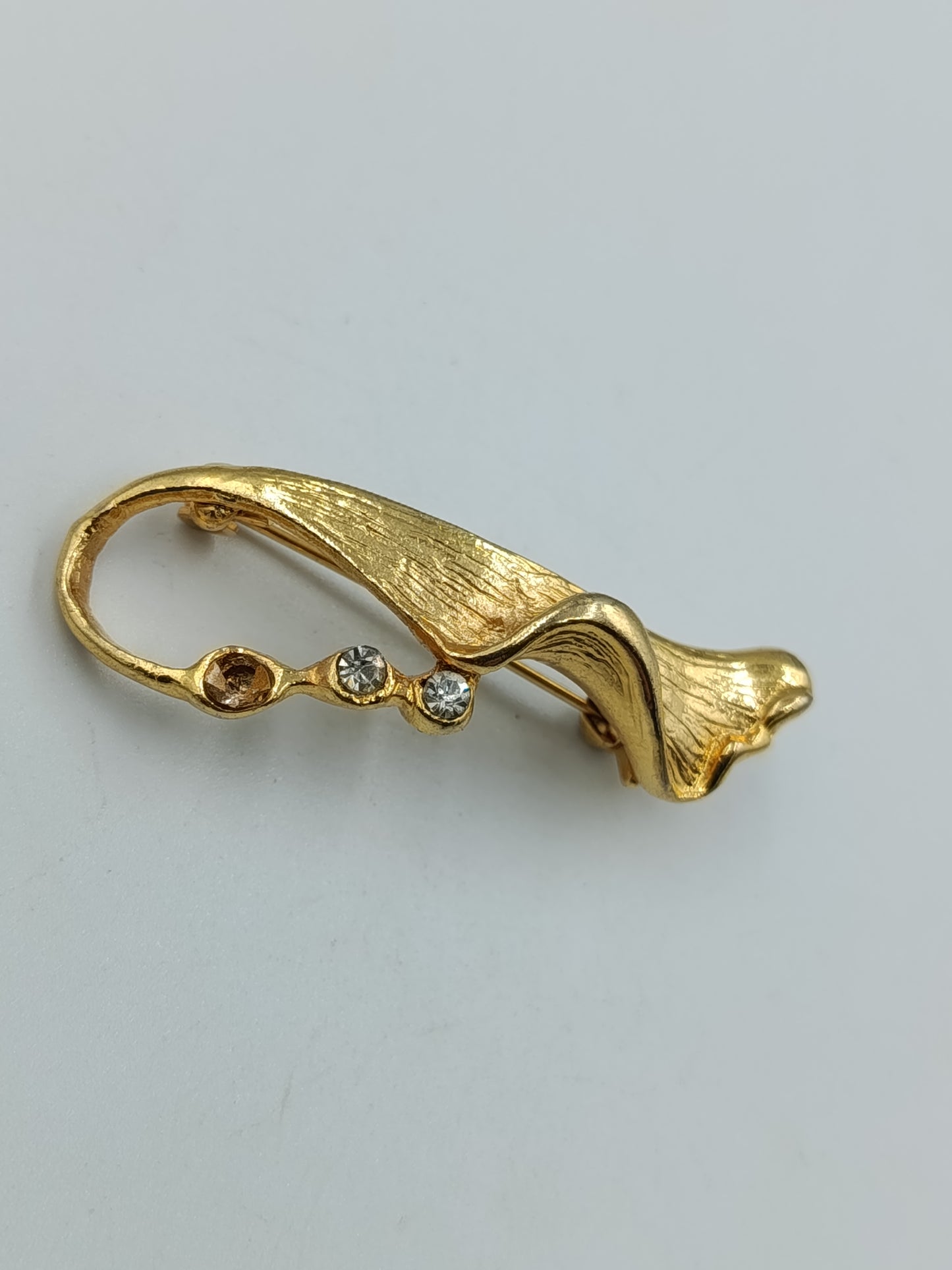 Moderne goldfarbene Brosche mit Strasssteinen