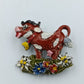 Farbenfrohe Kuh-Brosche mit Blumenmotiv