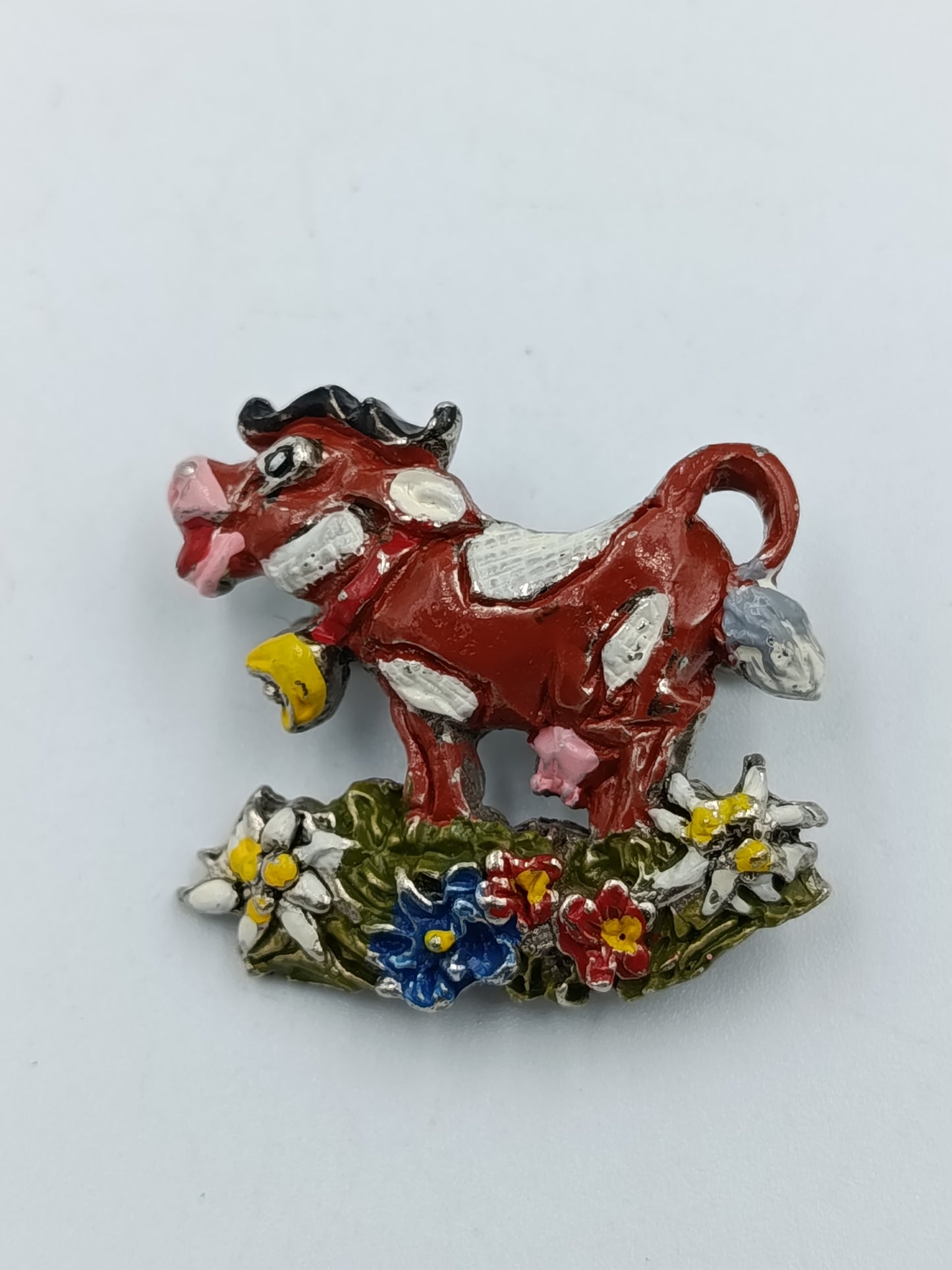 Farbenfrohe Kuh-Brosche mit Blumenmotiv