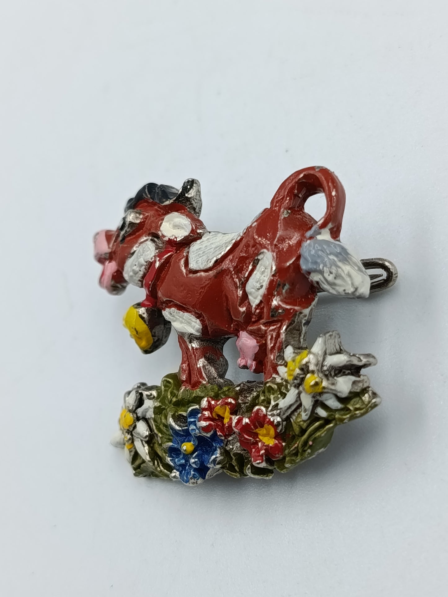 Farbenfrohe Kuh-Brosche mit Blumenmotiv