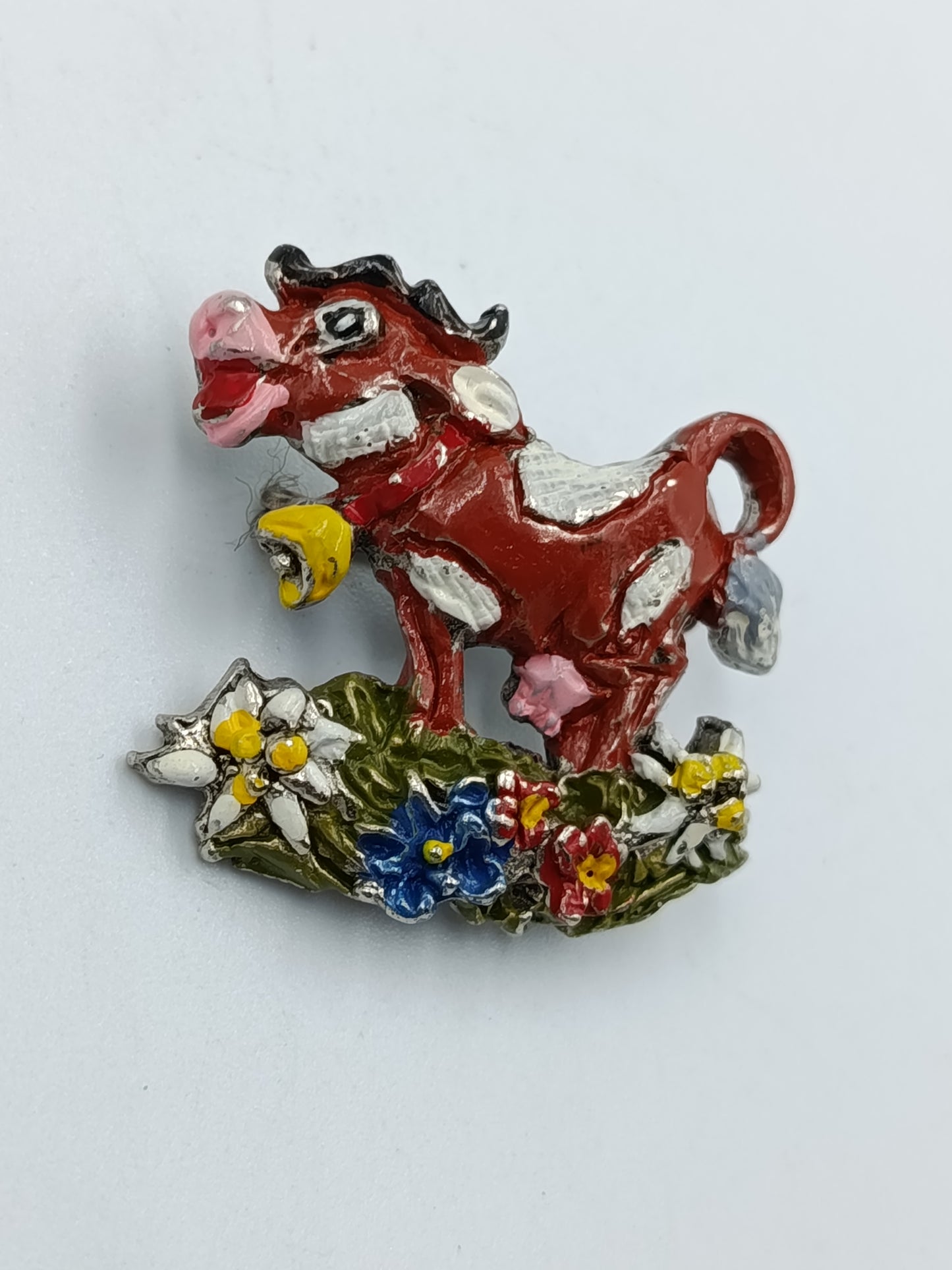 Farbenfrohe Kuh-Brosche mit Blumenmotiv