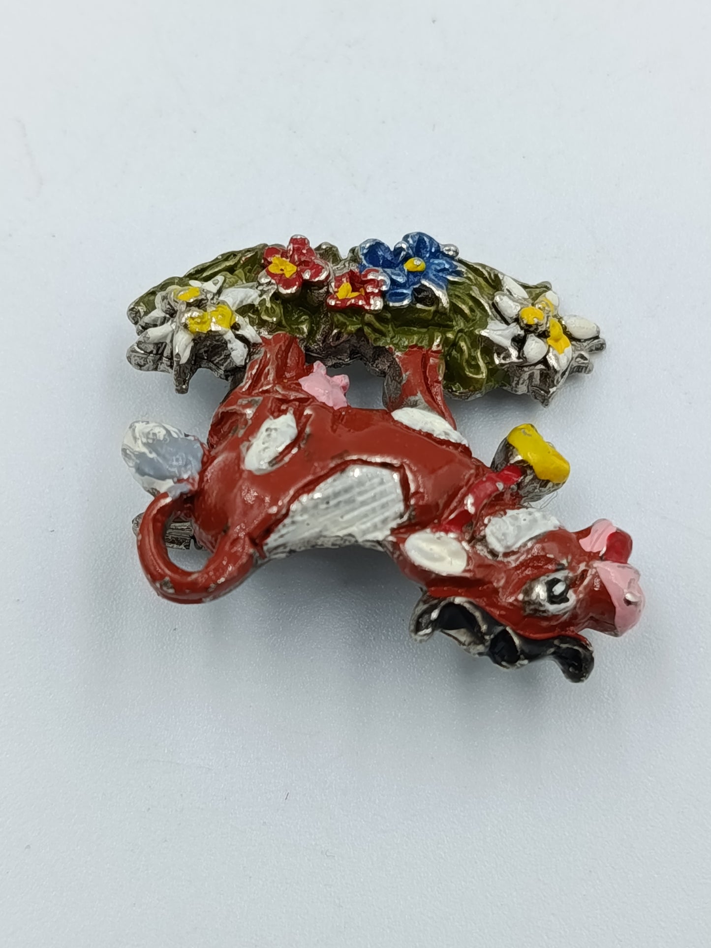 Farbenfrohe Kuh-Brosche mit Blumenmotiv