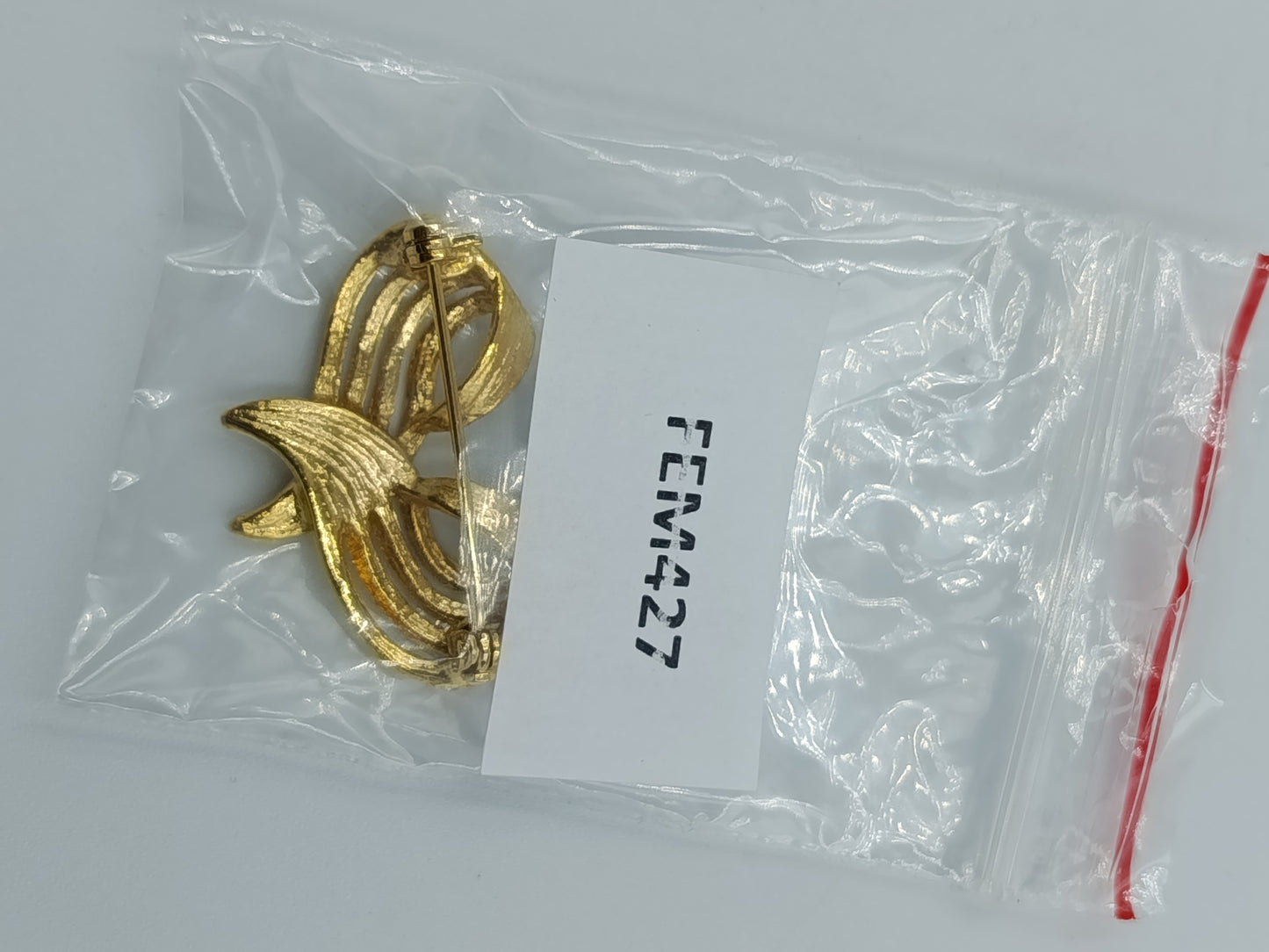 Elegante goldfarbene Brosche mit Strassakzent