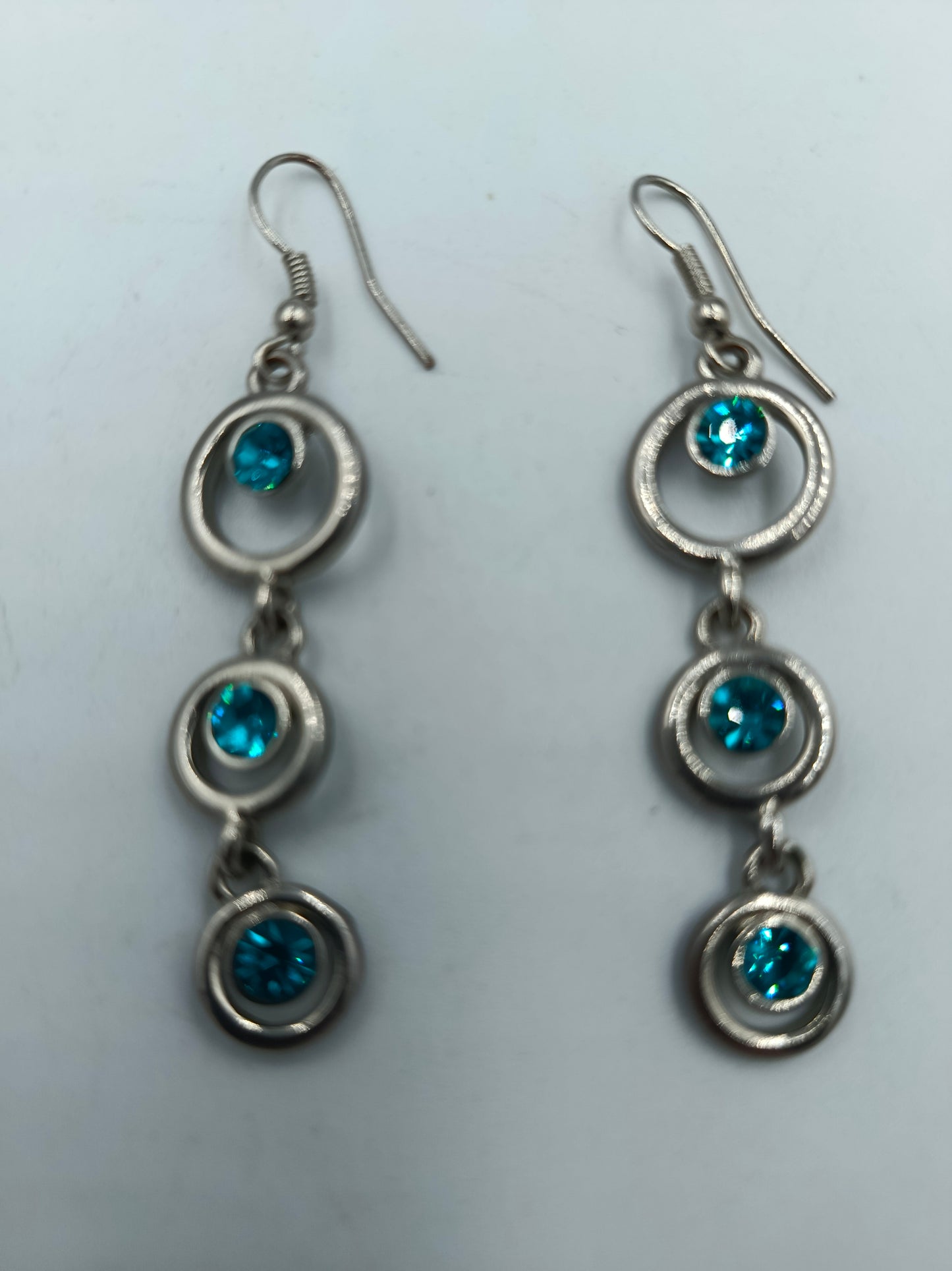 Silberfarbene Ohrhänger mit blauen Kristallen