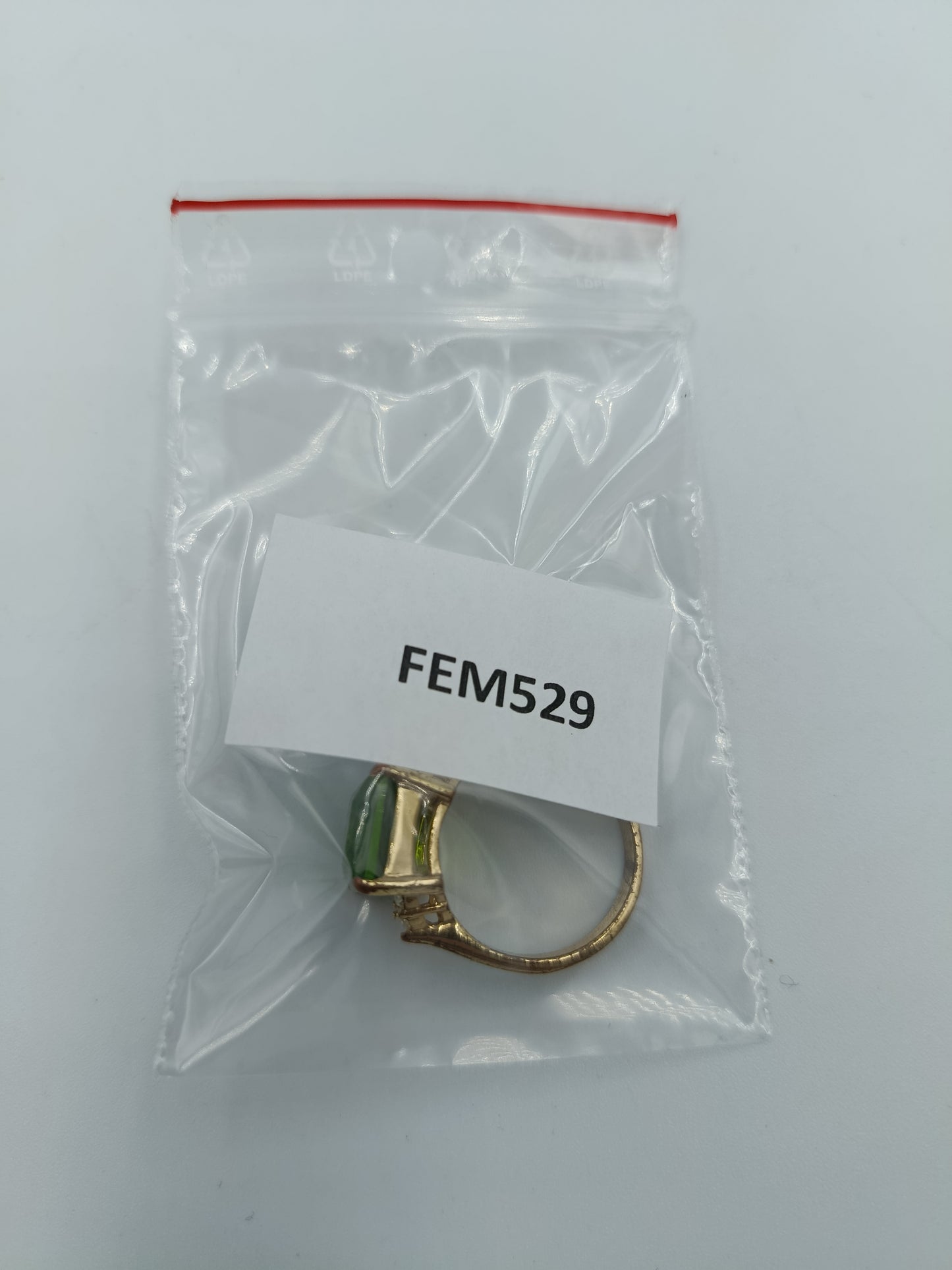 Goldfarbener Ring mit grünem rechteckigem Stein