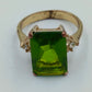 Goldfarbener Ring mit grünem rechteckigem Stein