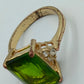 Goldfarbener Ring mit grünem rechteckigem Stein
