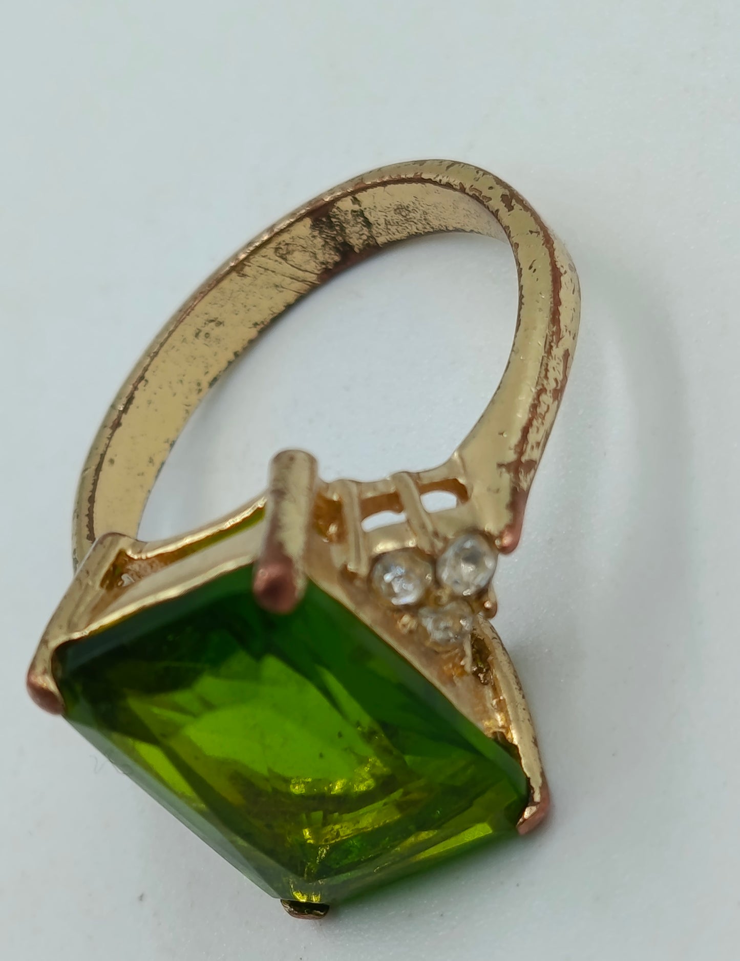Goldfarbener Ring mit grünem rechteckigem Stein
