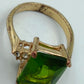 Goldfarbener Ring mit grünem rechteckigem Stein