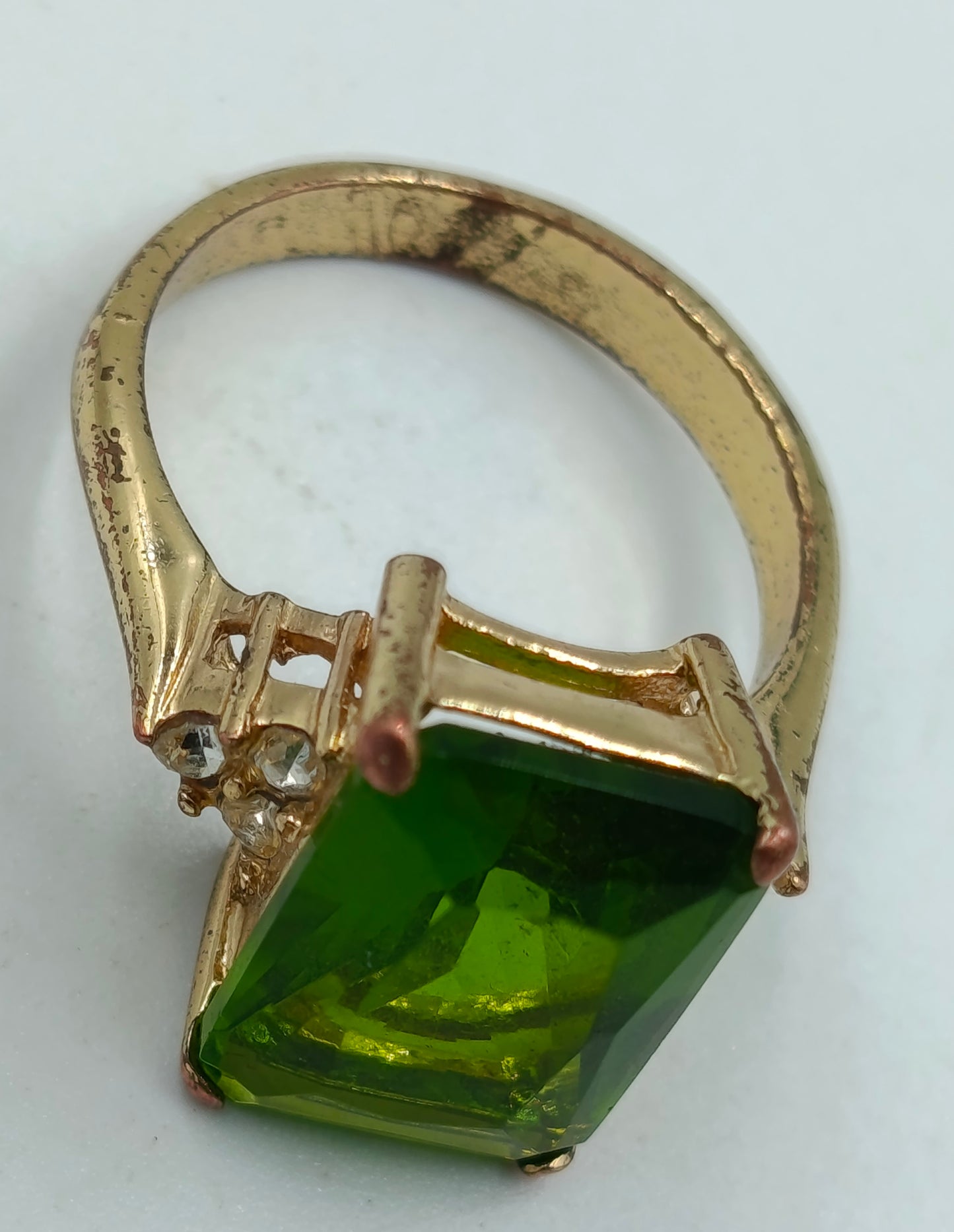 Goldfarbener Ring mit grünem rechteckigem Stein