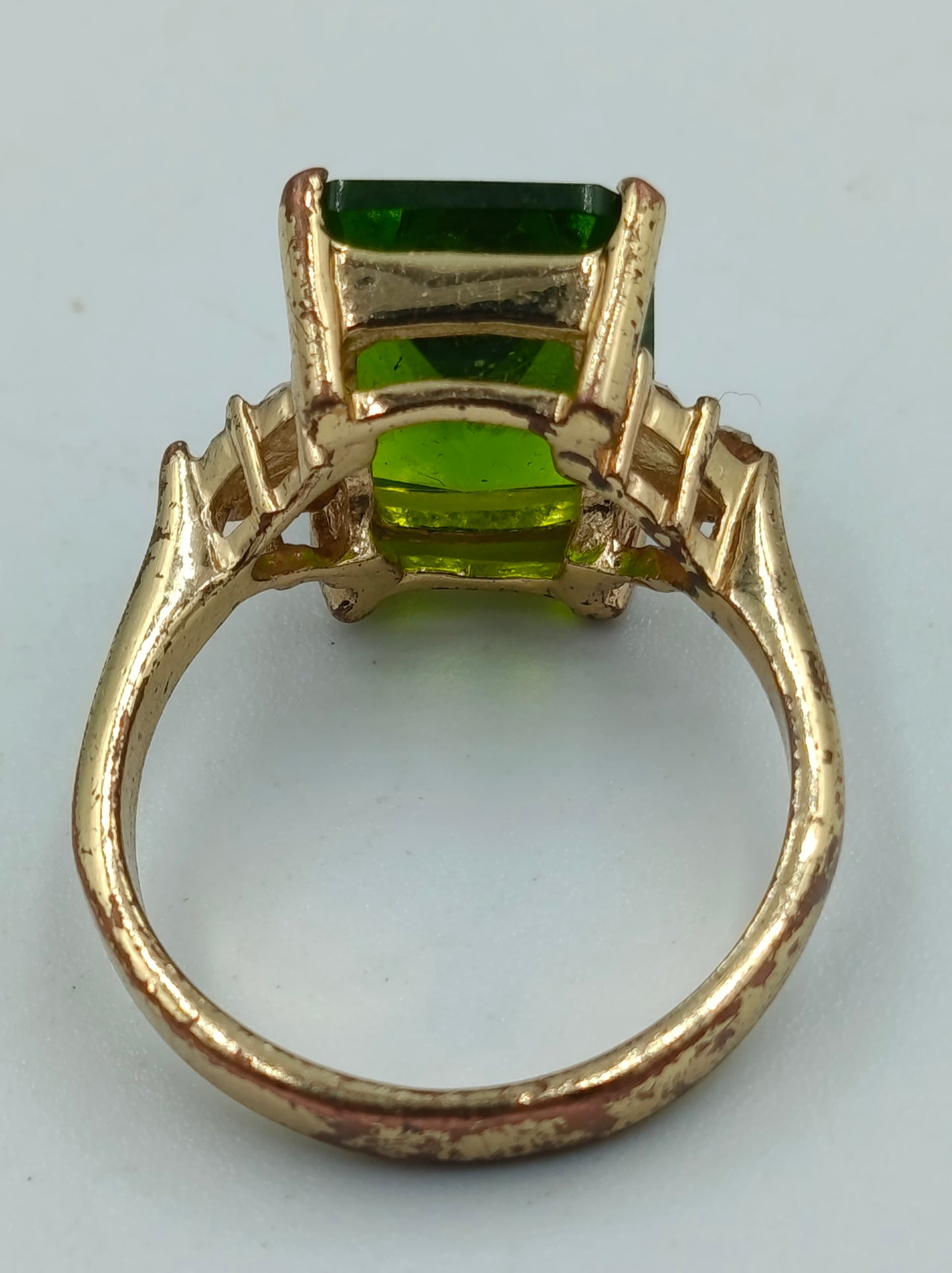 Goldfarbener Ring mit grünem rechteckigem Stein