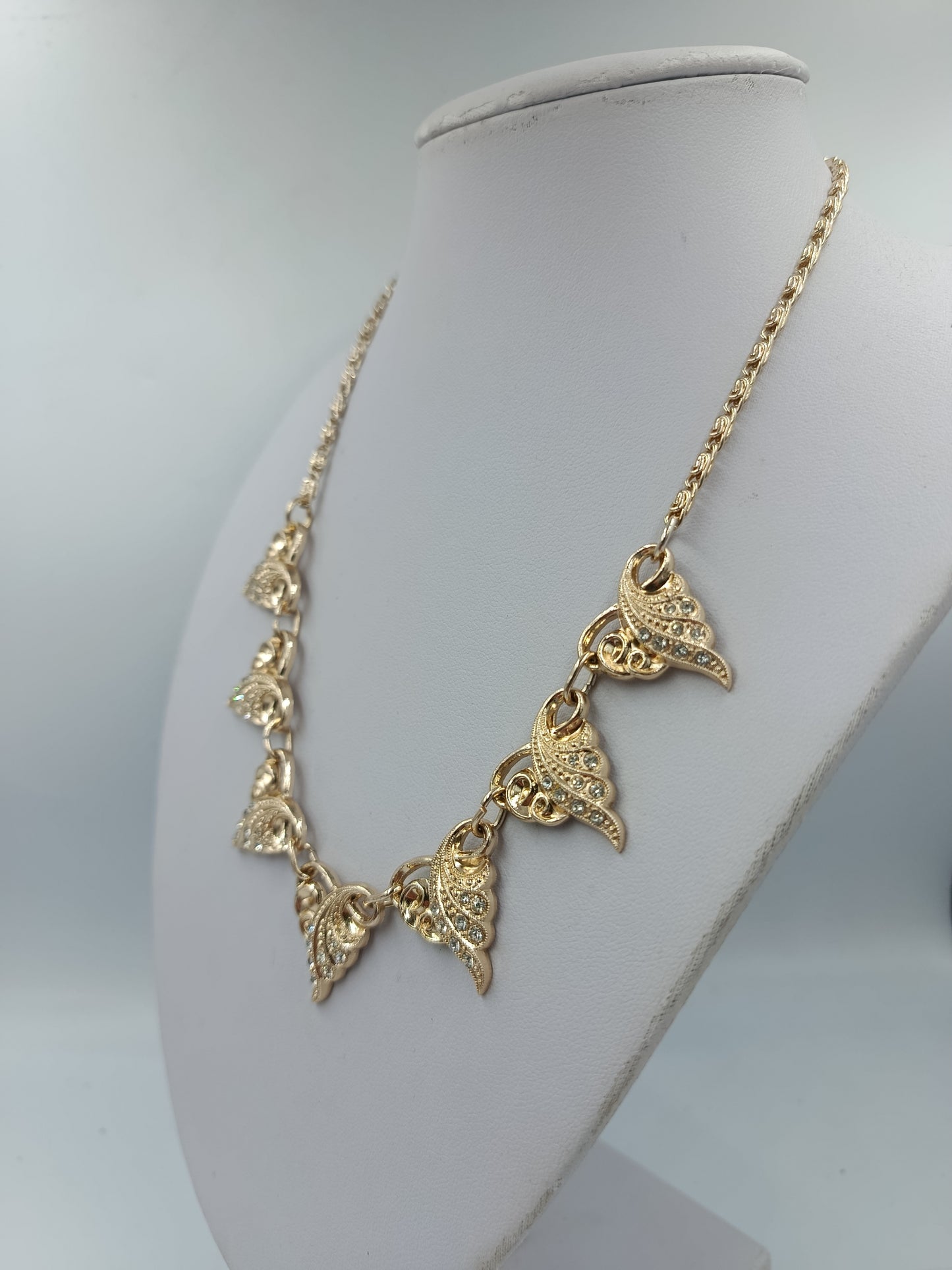 Goldfarbene Halskette mit funkelnden Blätterelementen