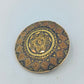 Runde goldfarbene Brosche mit orientalischem Muster