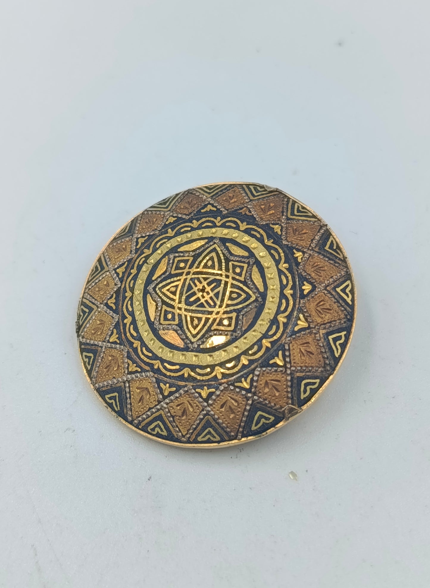 Runde goldfarbene Brosche mit orientalischem Muster