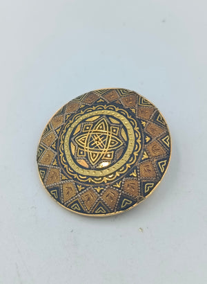 Runde goldfarbene Brosche mit orientalischem Muster