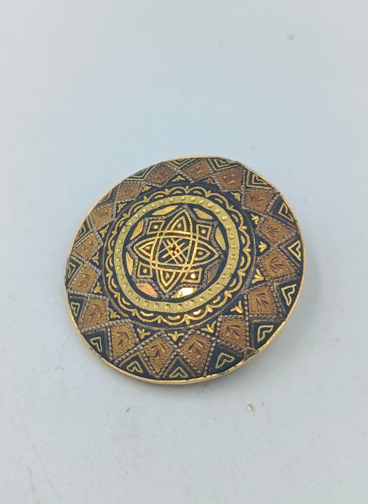 Runde goldfarbene Brosche mit orientalischem Muster