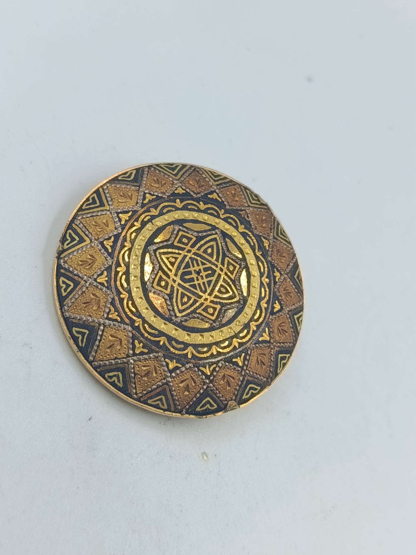 Runde goldfarbene Brosche mit orientalischem Muster