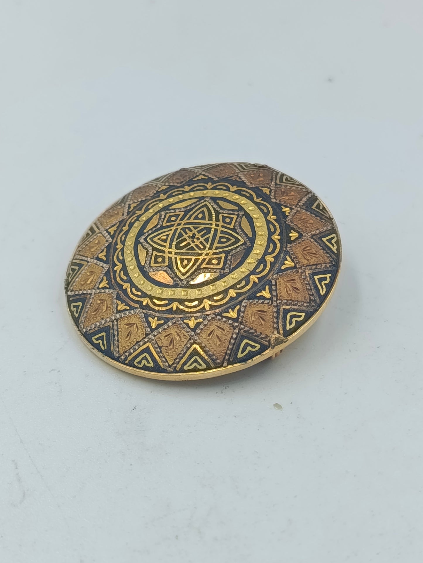 Runde goldfarbene Brosche mit orientalischem Muster