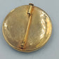 Runde goldfarbene Brosche mit orientalischem Muster