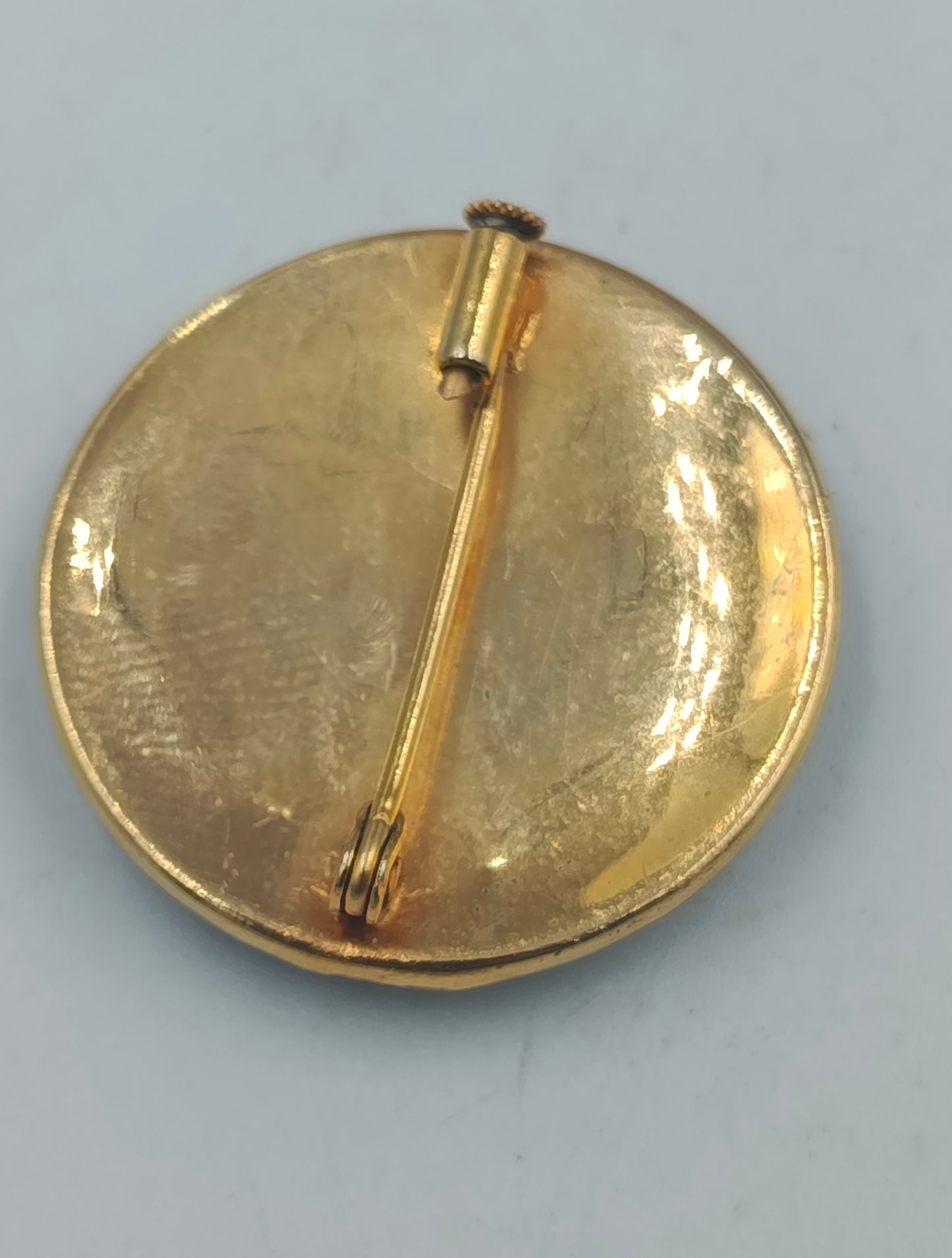 Runde goldfarbene Brosche mit orientalischem Muster