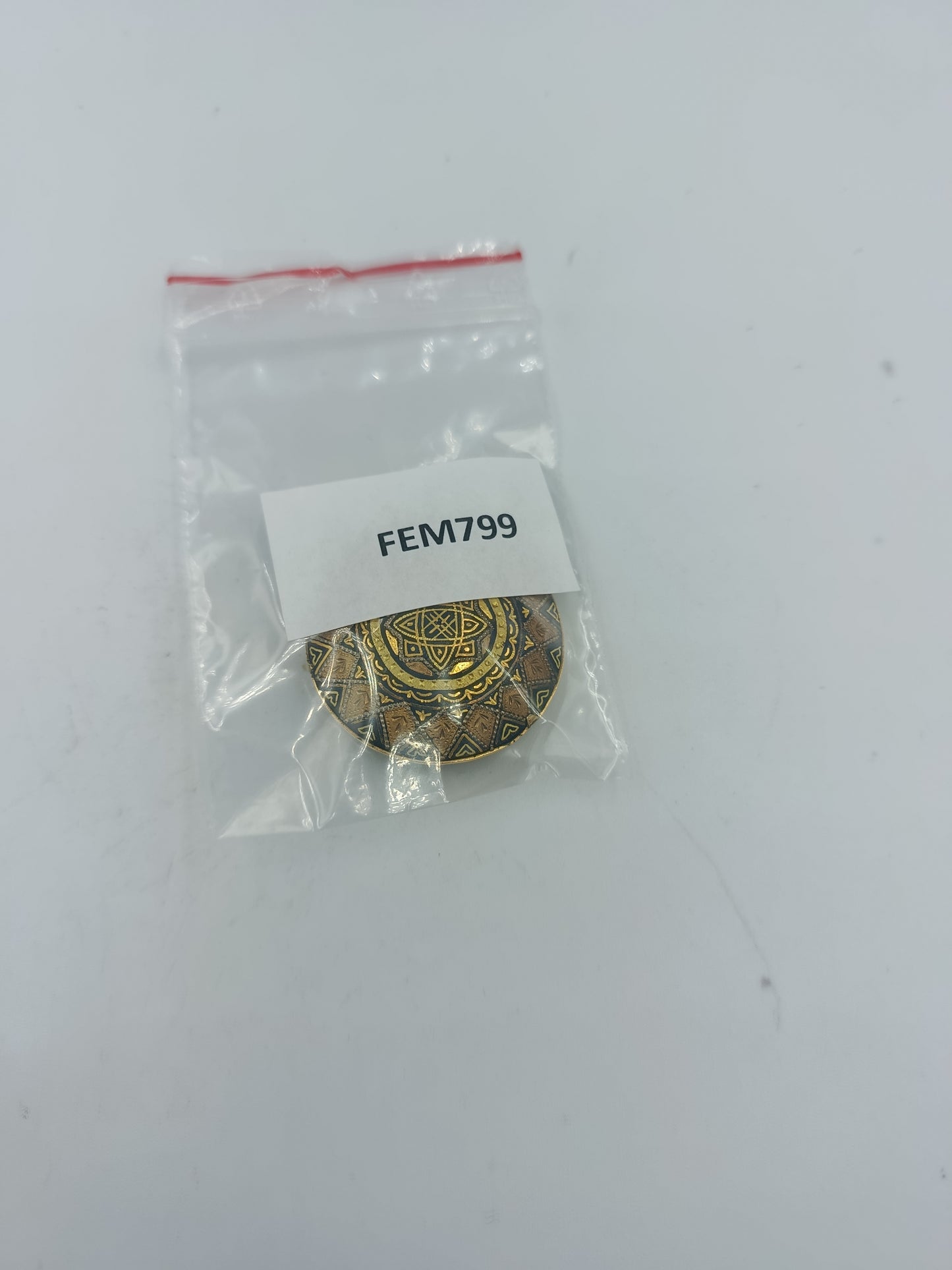 Runde goldfarbene Brosche mit orientalischem Muster