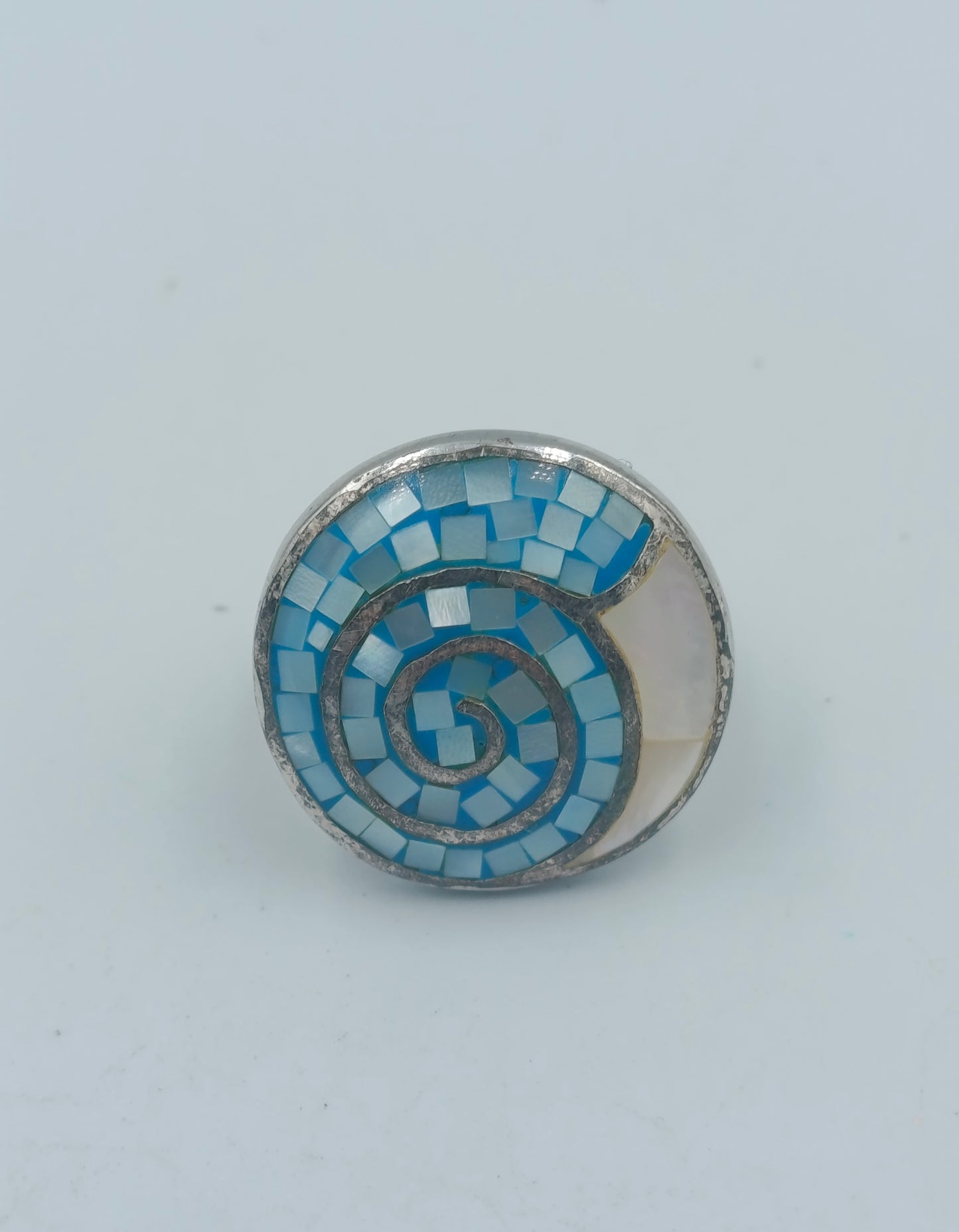 Silberfarbener Mosaikring mit blauer Spirale