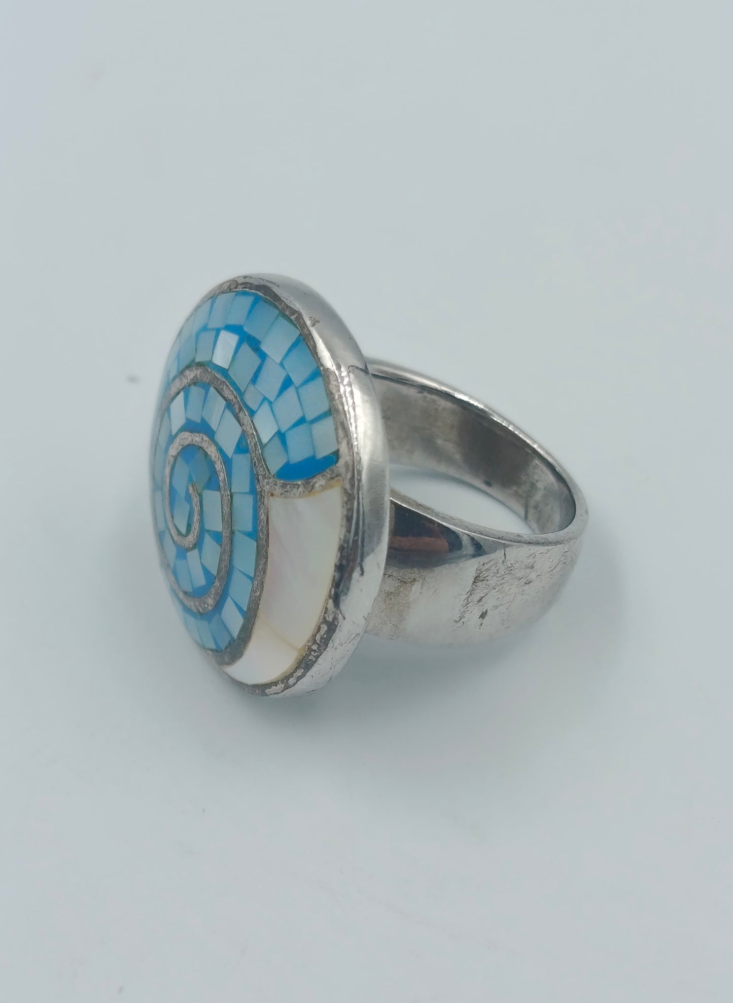 Silberfarbener Mosaikring mit blauer Spirale
