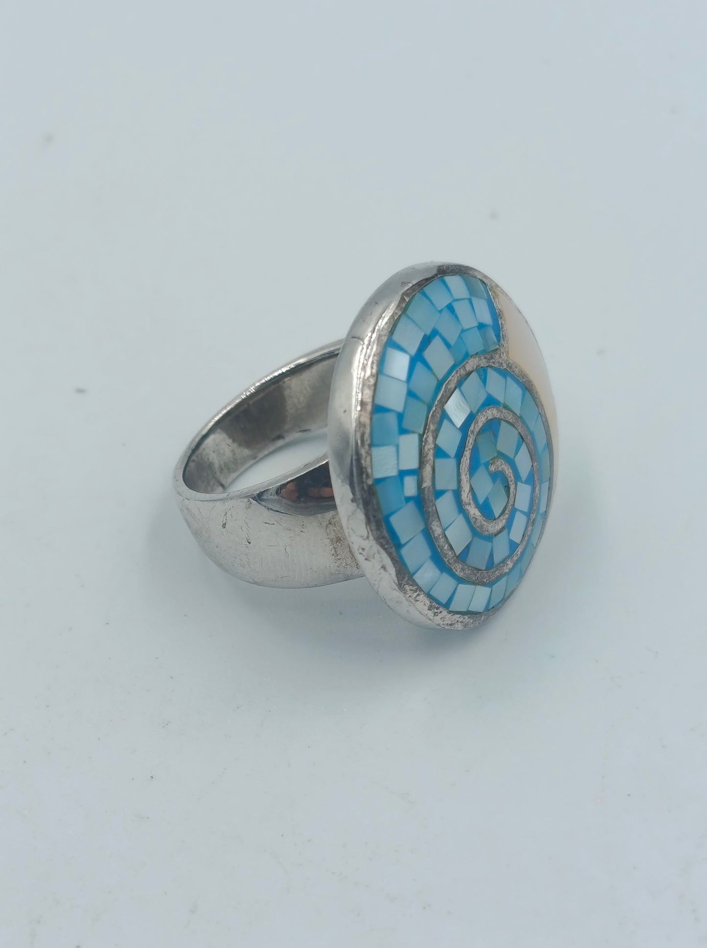 Silberfarbener Mosaikring mit blauer Spirale