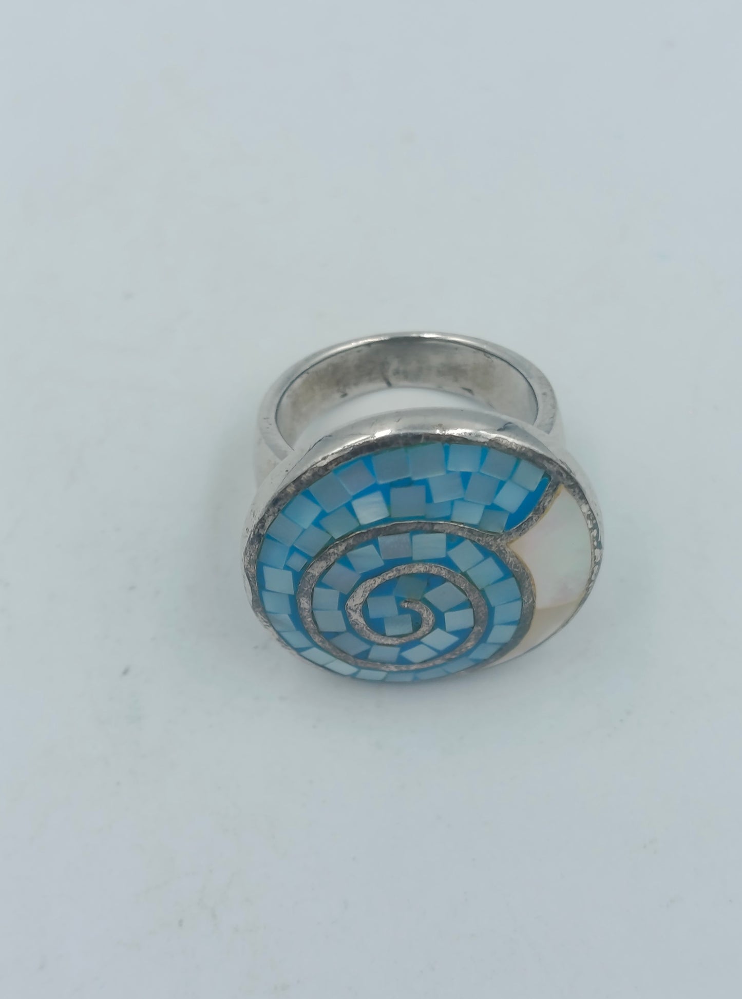 Silberfarbener Mosaikring mit blauer Spirale