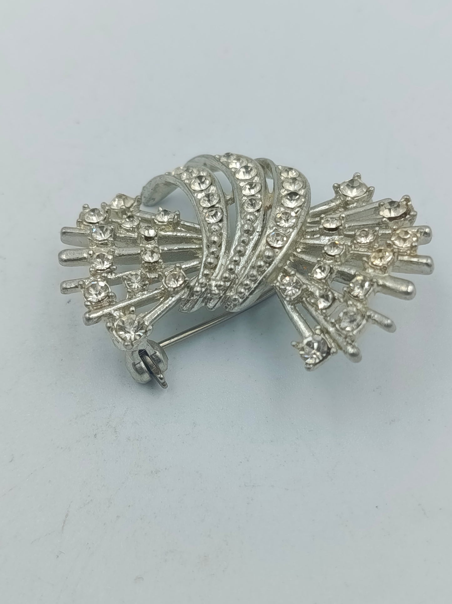 Silberfarbene Brosche mit klaren Strasssteinen