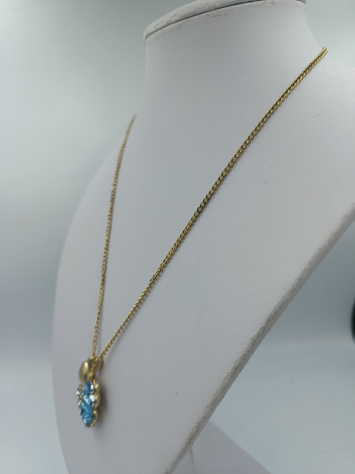 Goldfarbene Kette mit Kleeblattanhänger und blauen Steinen