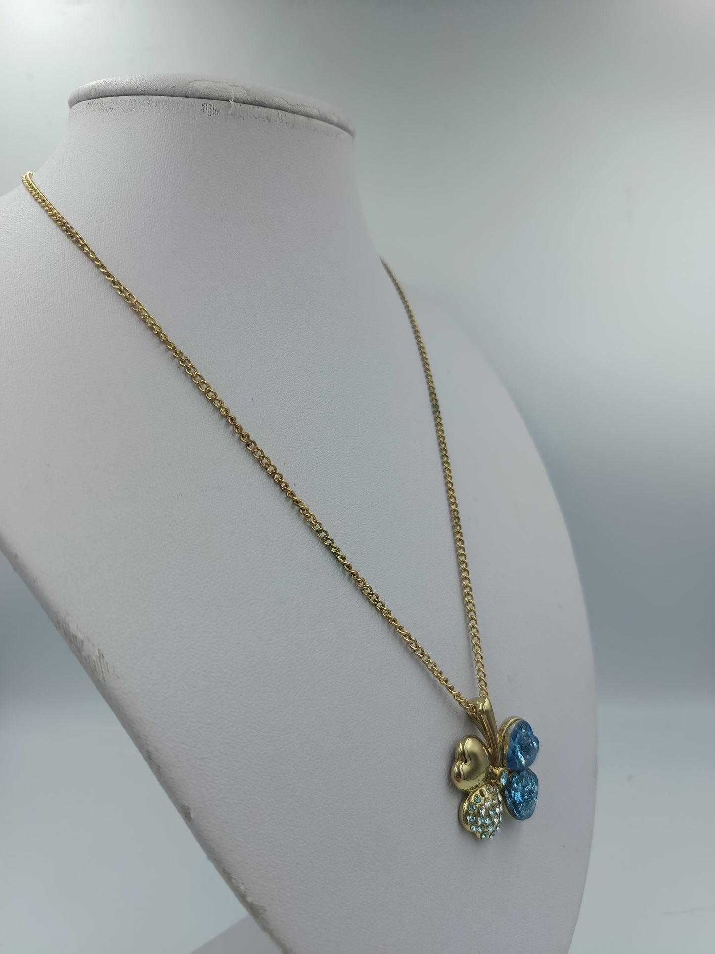 Goldfarbene Kette mit Kleeblattanhänger und blauen Steinen