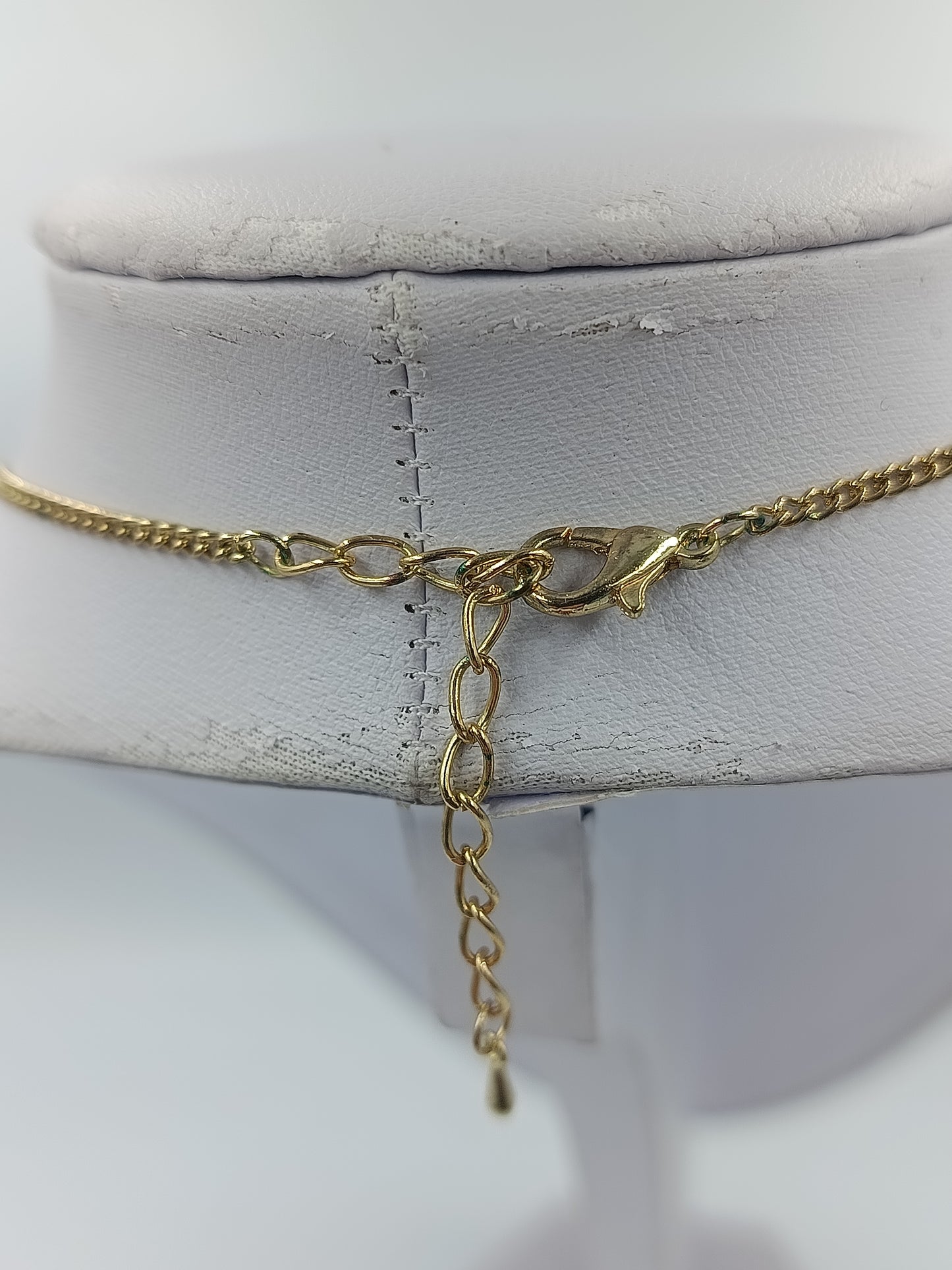 Goldfarbene Kette mit Kleeblattanhänger und blauen Steinen