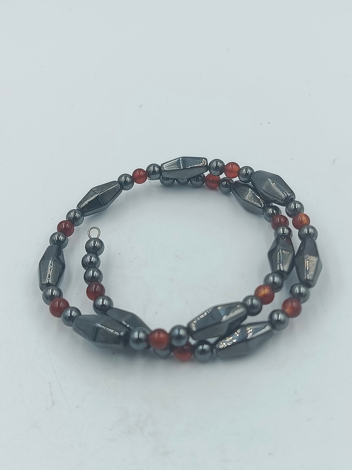 Elastisches Hämatit Armband mit roten Zierperlen