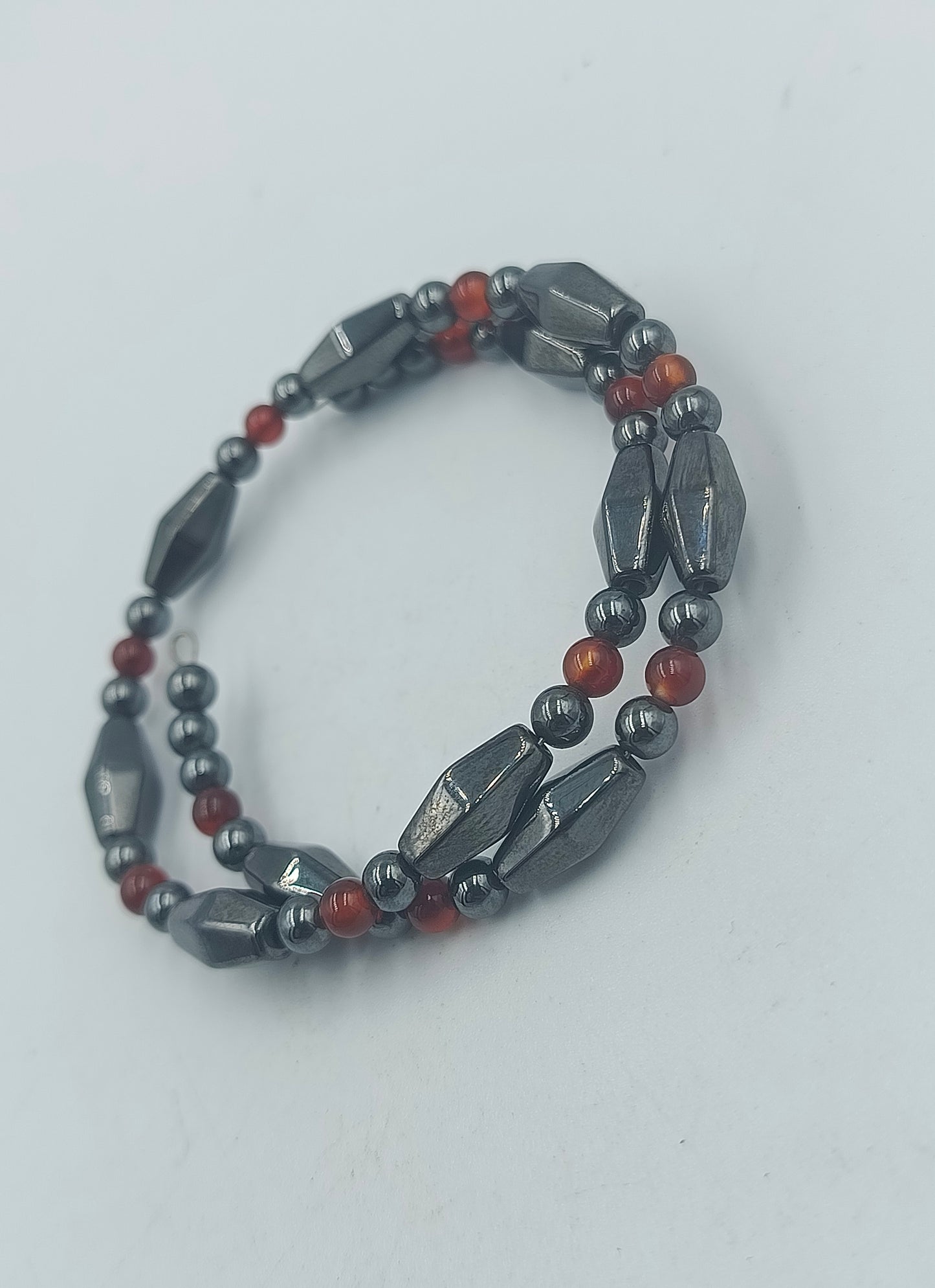 Elastisches Hämatit Armband mit roten Zierperlen