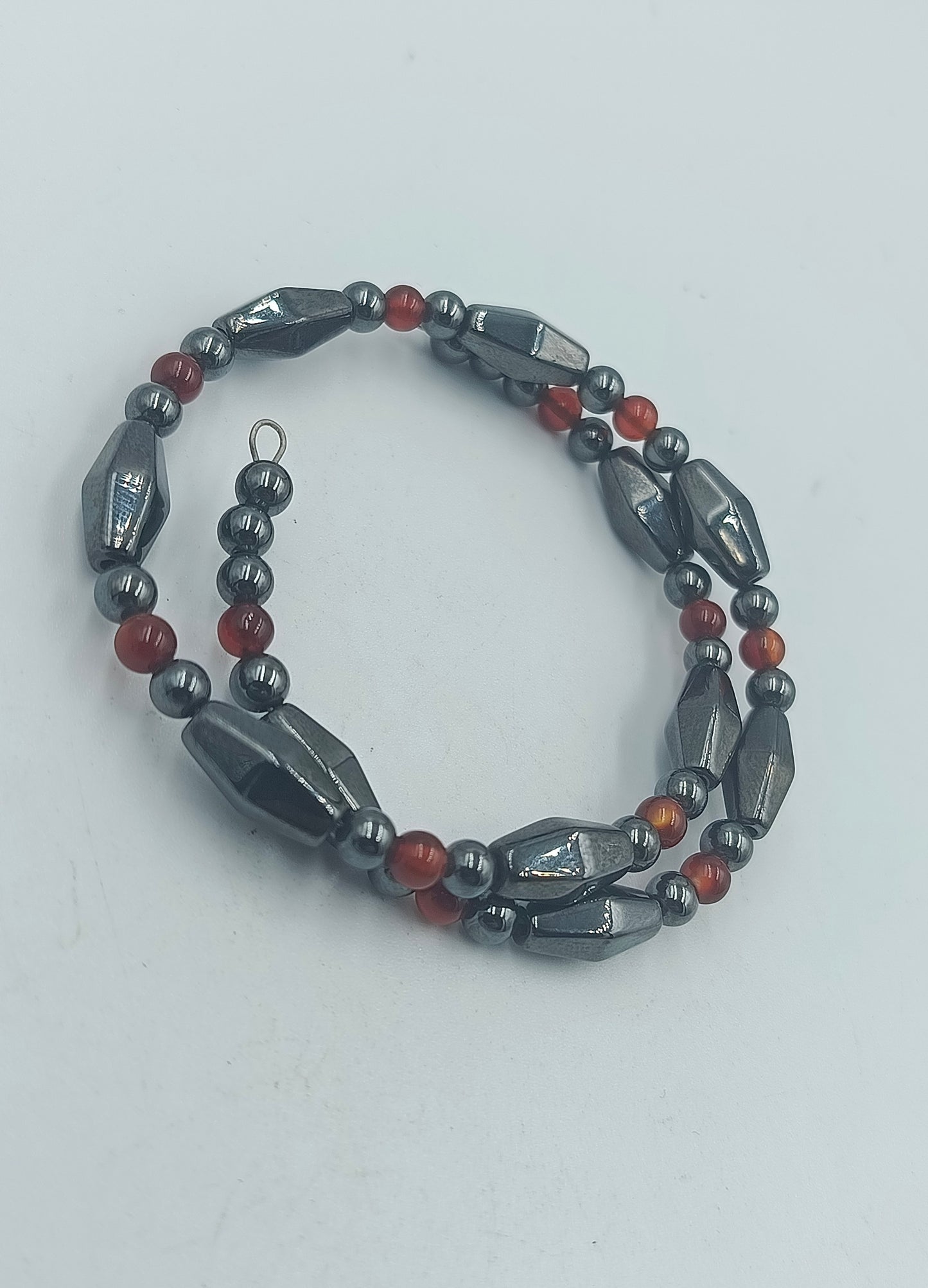 Elastisches Hämatit Armband mit roten Zierperlen