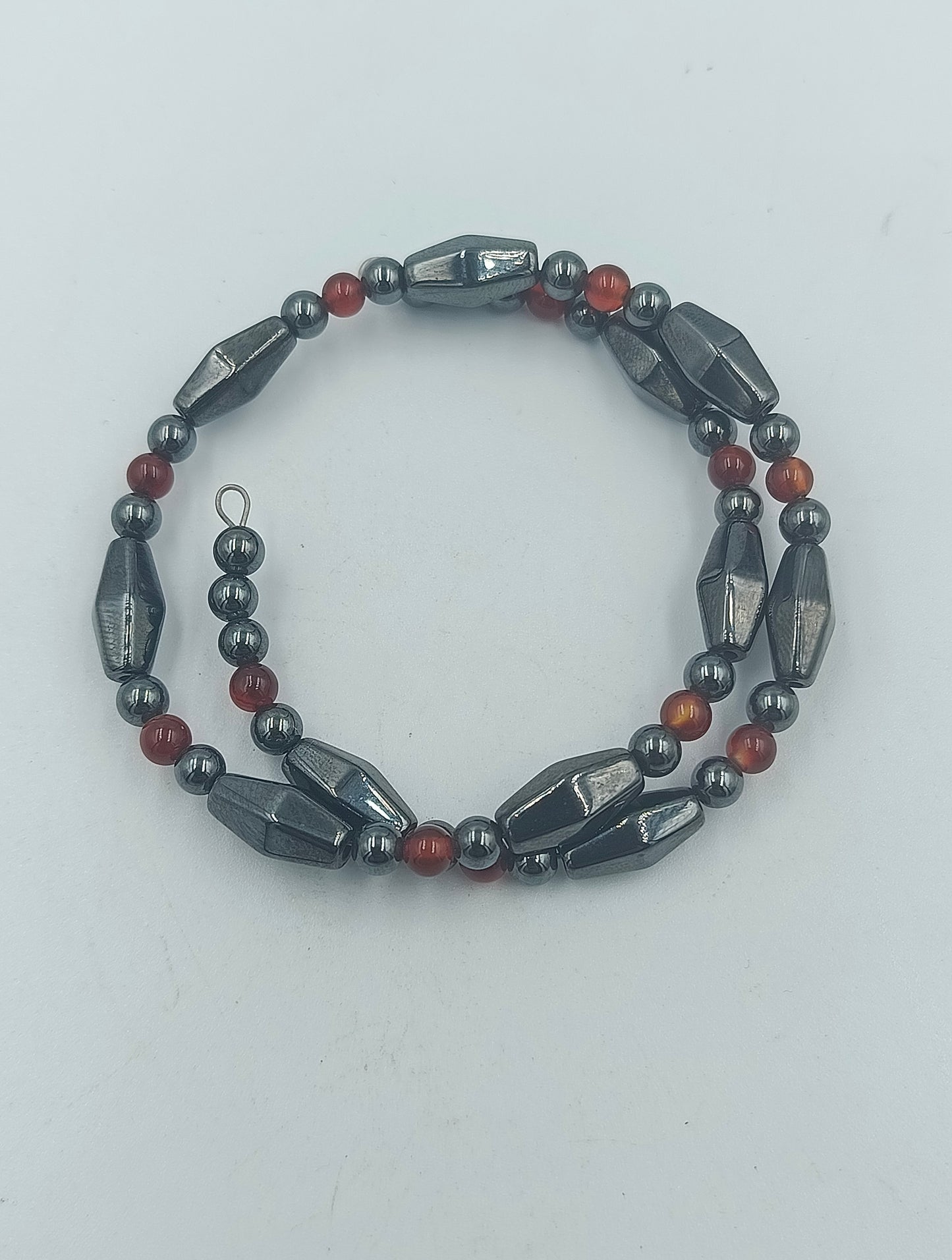 Elastisches Hämatit Armband mit roten Zierperlen