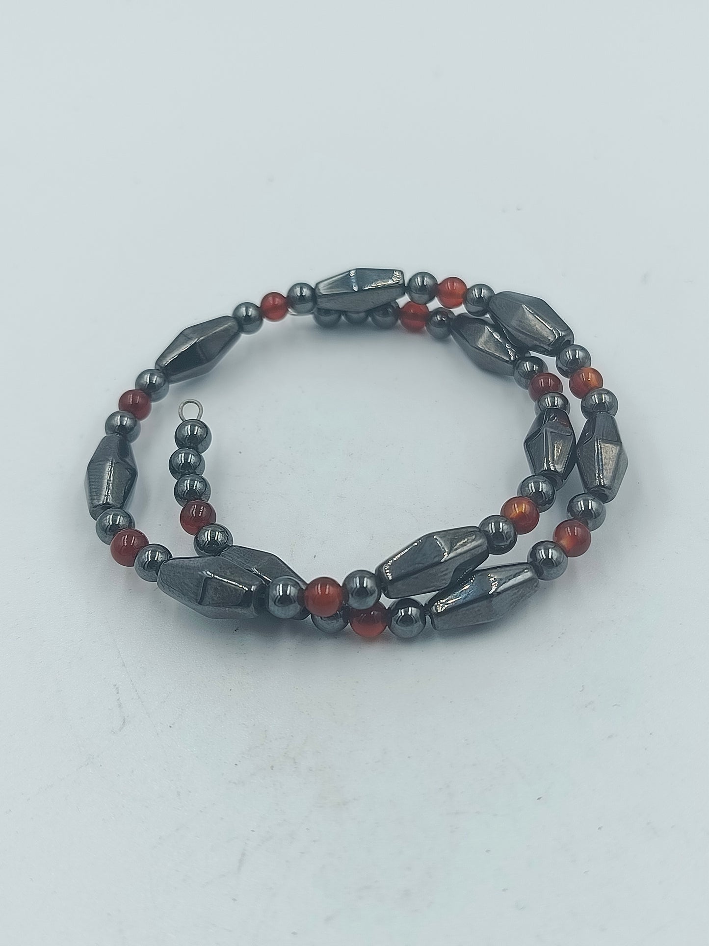 Elastisches Hämatit Armband mit roten Zierperlen