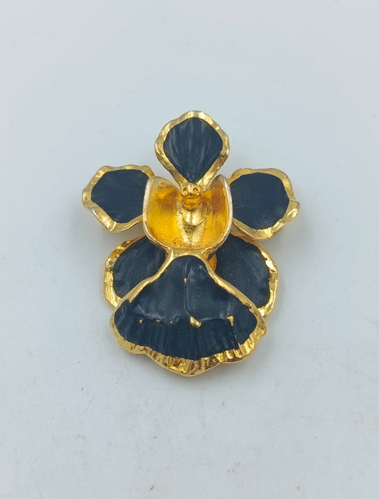 Goldfarbene Blütenbrosche mit schwarzer Emaille