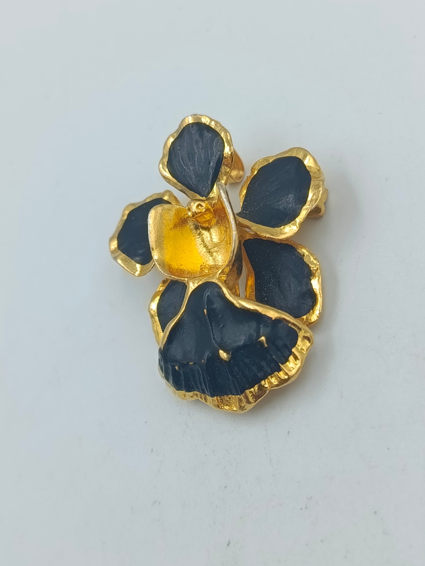 Goldfarbene Blütenbrosche mit schwarzer Emaille