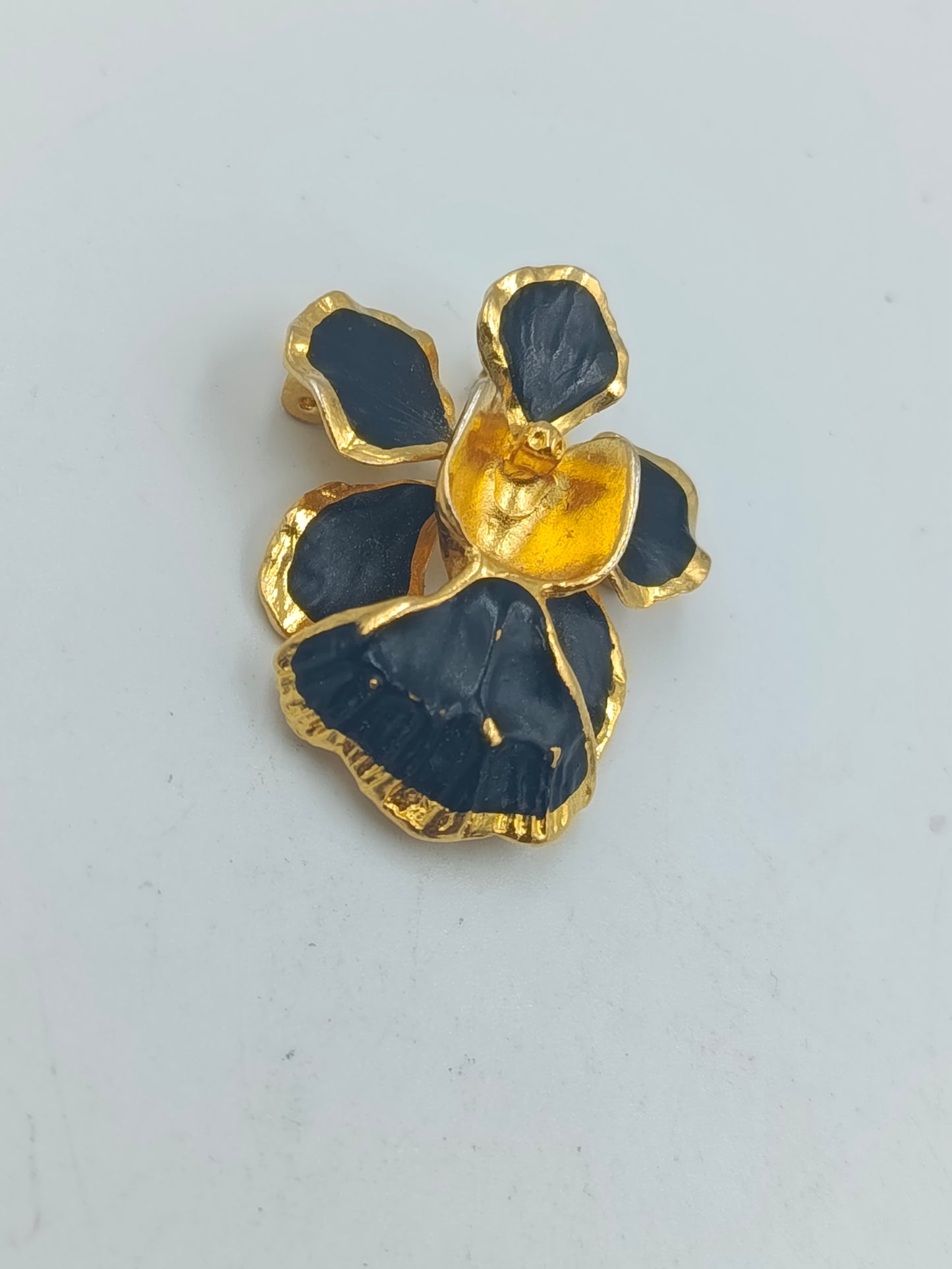 Goldfarbene Blütenbrosche mit schwarzer Emaille
