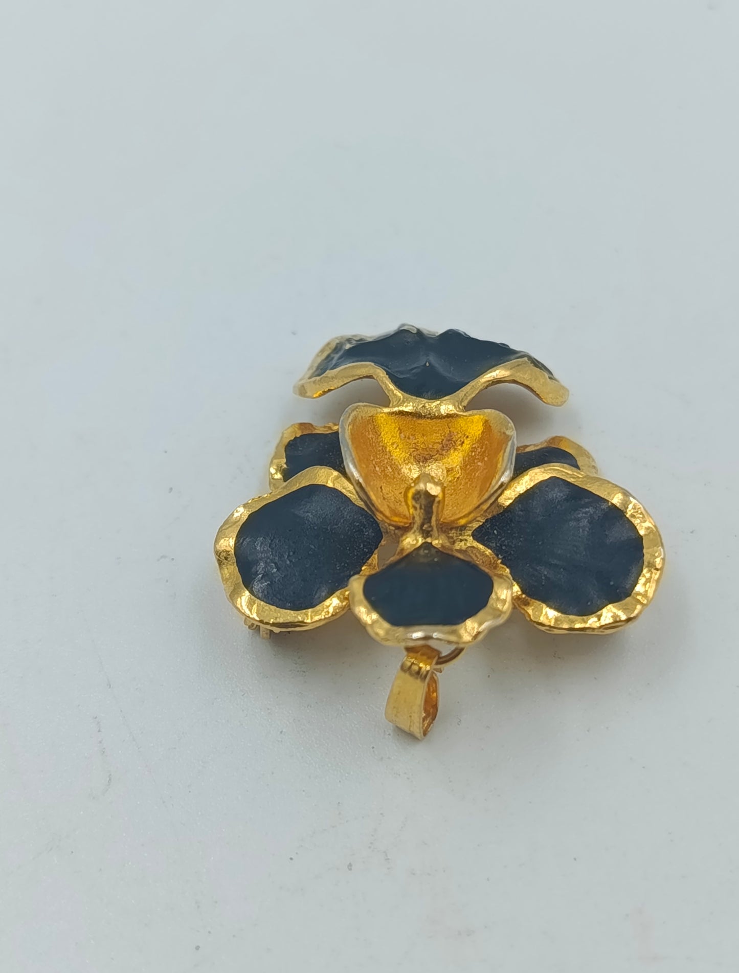 Goldfarbene Blütenbrosche mit schwarzer Emaille
