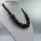 Schwarze Designer Halskette mit runden und gedrehten Perlen im modernen Statement Look