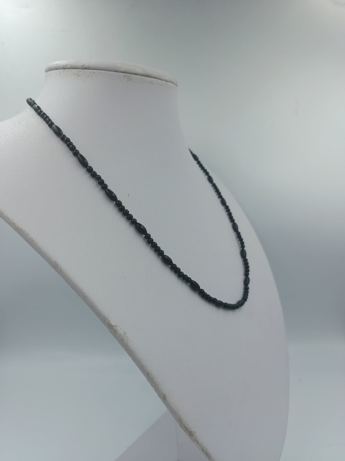 Feine schwarze Perlenkette mit goldfarbenen Akzenten im eleganten minimalistischen Design